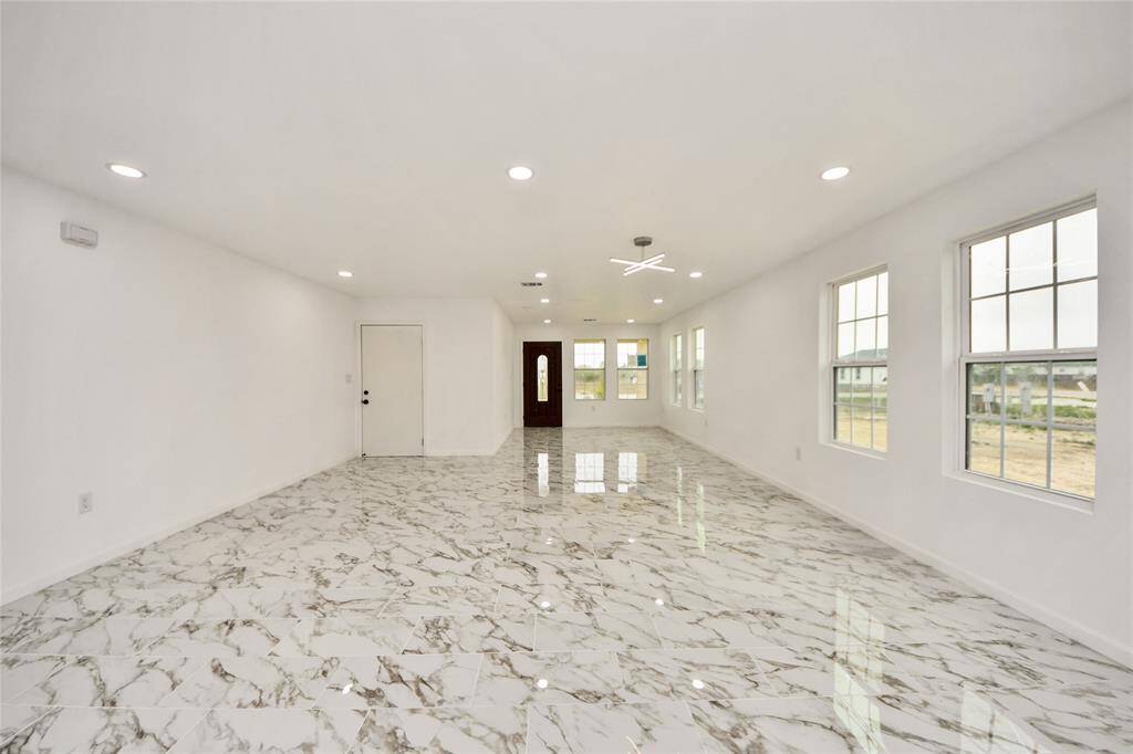 Spacious open-plan design offering a continuous flow from the front entrance through the living and dining areas, with expansive windows framing outdoor views.