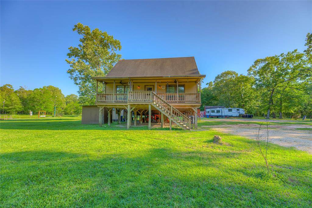 Beautiful front of home with big, long covered porch complete with fans for enjoying the lazy days & cool evenings