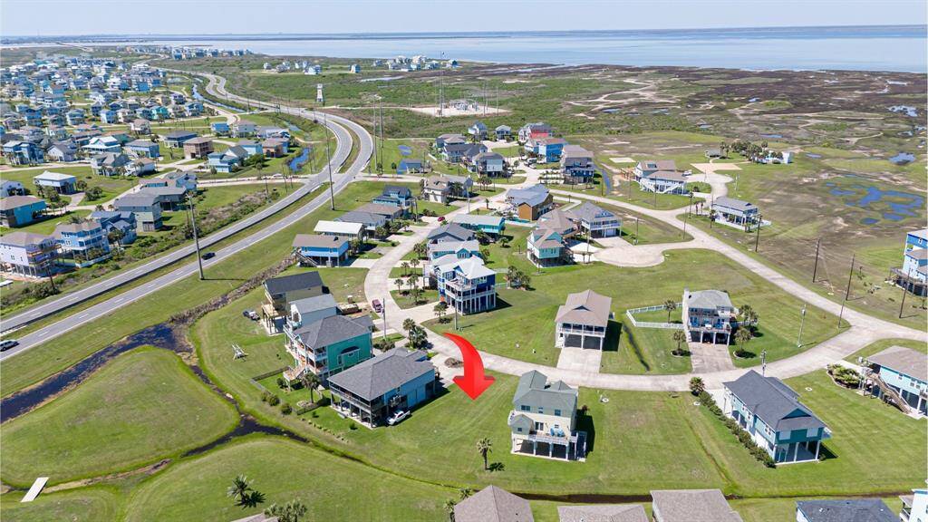 An expansive aerial reveals the surrounding coastal neighborhood and how this lot sits just a short reach from the water’s edge.