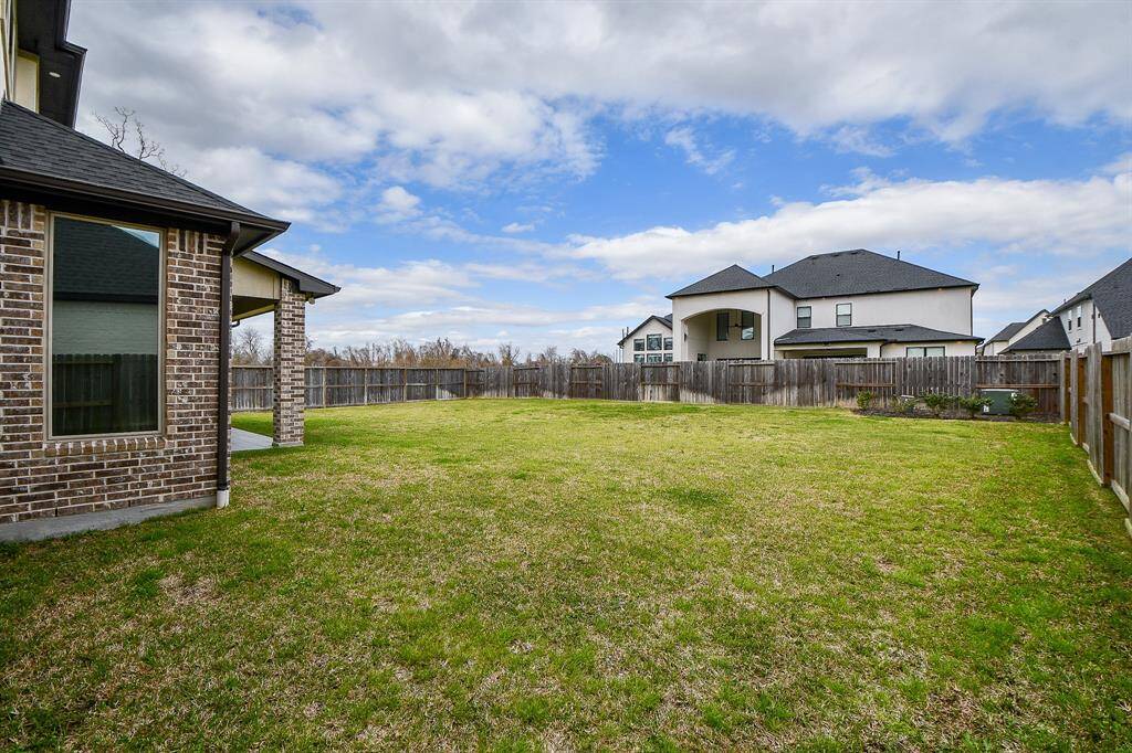 Lovely large covered patio with tile floors and ceiling fan