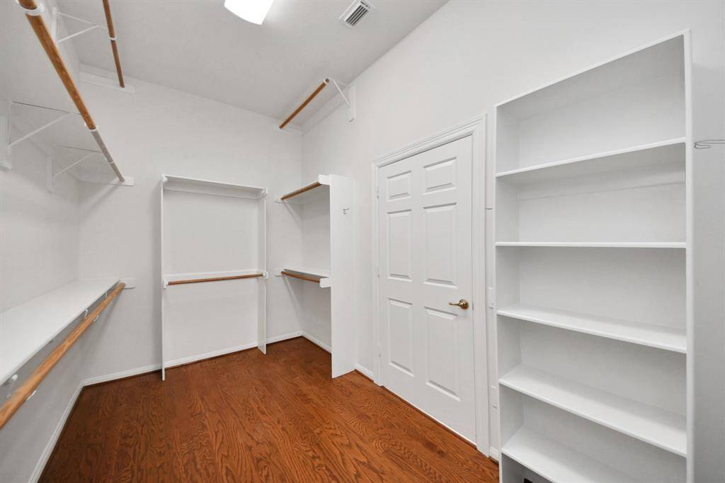 generous walk-in closet is thoughtfully designed with custom-built shelving, providing abundant storage for your wardrobe and accessories