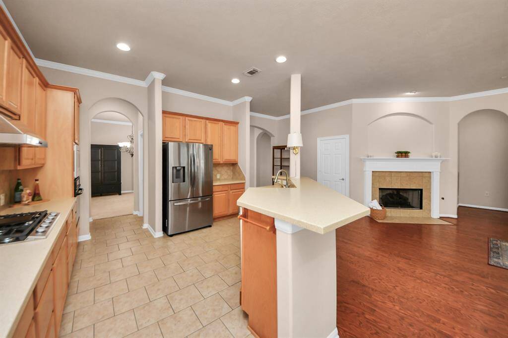 This chef-inspired kitchen boasts sleek countertops, high-end appliances, and ample cabinetry. An open layout provides a clear view into the elegant formal living area, creating a harmonious space ideal for both entertaining and everyday living