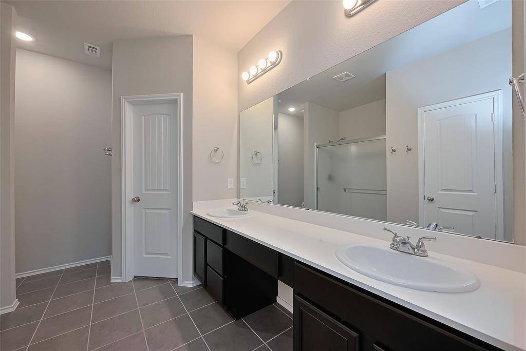 This spa like bathroom features double vanities, walk in shower, and walk in closet!