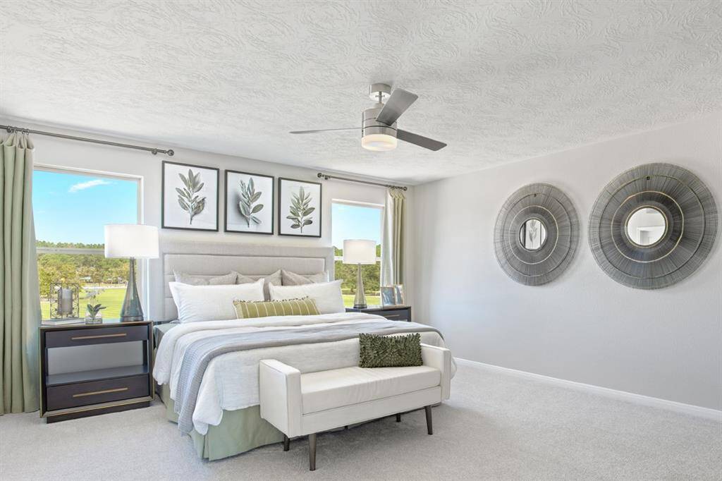 Come and unwind after a long day in this magnificent and spacious primary suite! Featuring plush carpet, custom paint, high ceilings, ceiling fan, and large windows with window coverings. Note that window coverings and artwork will be sold with the home.