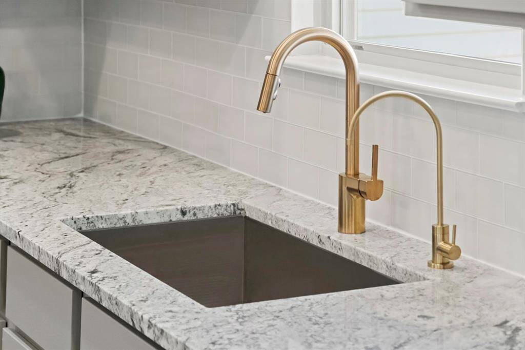 Pictured here is the self-rimming single bowl stainless steel kitchen sink with Moen faucet with pull down spout in brushed gold. Also featured here is the Purita kitchen water filter faucet in brushed brass.