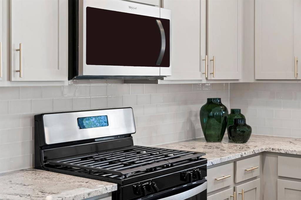 Kitchen comes equipped with Whirlpool stainless steel appliances. Pictured here is the stainless steel Whirlpool gas range and microwave.