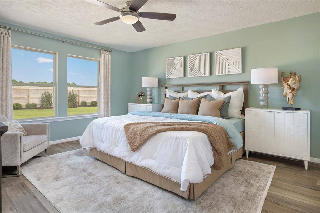 Come and unwind after a long day in this magnificent primary suite! This spacious room features vinyl plank flooring, custom paint, high ceilings, ceiling fan, and large windows with window coverings! Window coverings and artwork to be sold with home.