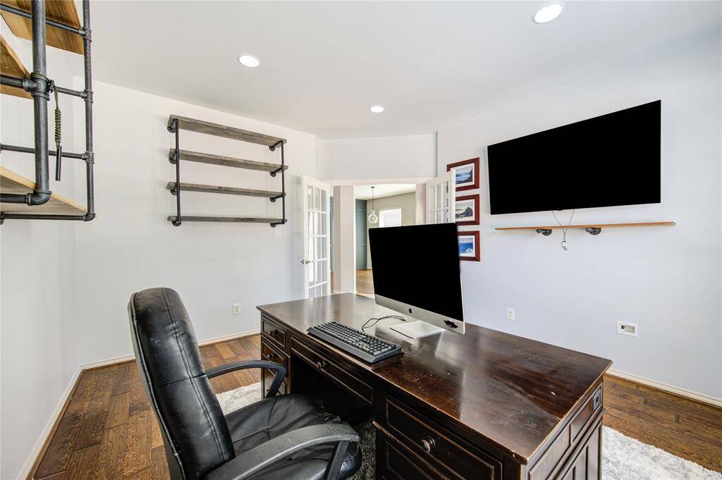 Office is framed by hardwood floors and modern shelves.