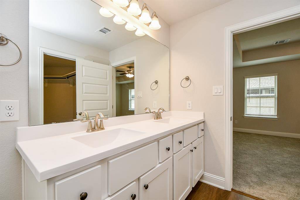 Primary bathroom featuring ample lighting and a separate tub & shower.