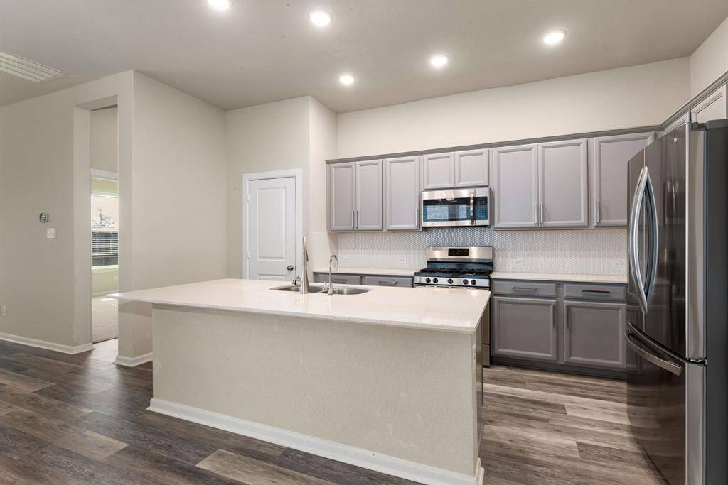 Boasting grey cabinetry and sleek stainless steel appliances, this kitchen combines style and functionality.