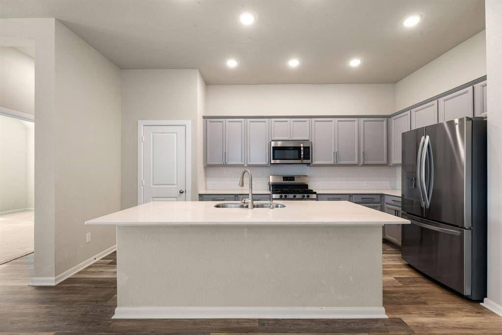 Features a large island with quartz countertops , perfect for meal prep, entertaining, or casual dining