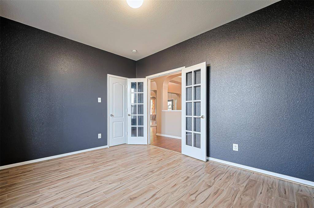 Private office (can also be converted to 5th bedroom since it has a closet) with glass French doors and new luxury laminate flooring