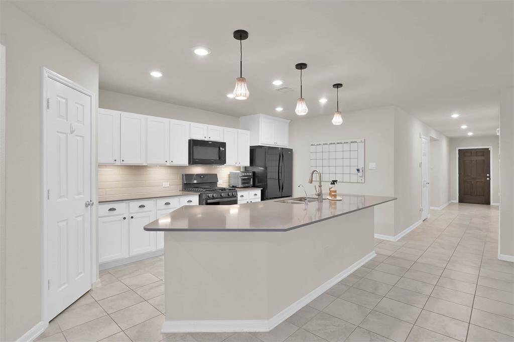 Kitchen has a large Silestone counter top  , gas stove, pendant lighting, Fridge included. Under cabinet lighting.