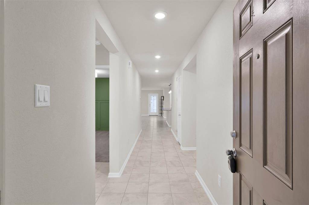 Front door looking down entry hall way. 2 bedrooms to the left separated by full bath, to the left is Bedroom #4 with its own full bathroom.