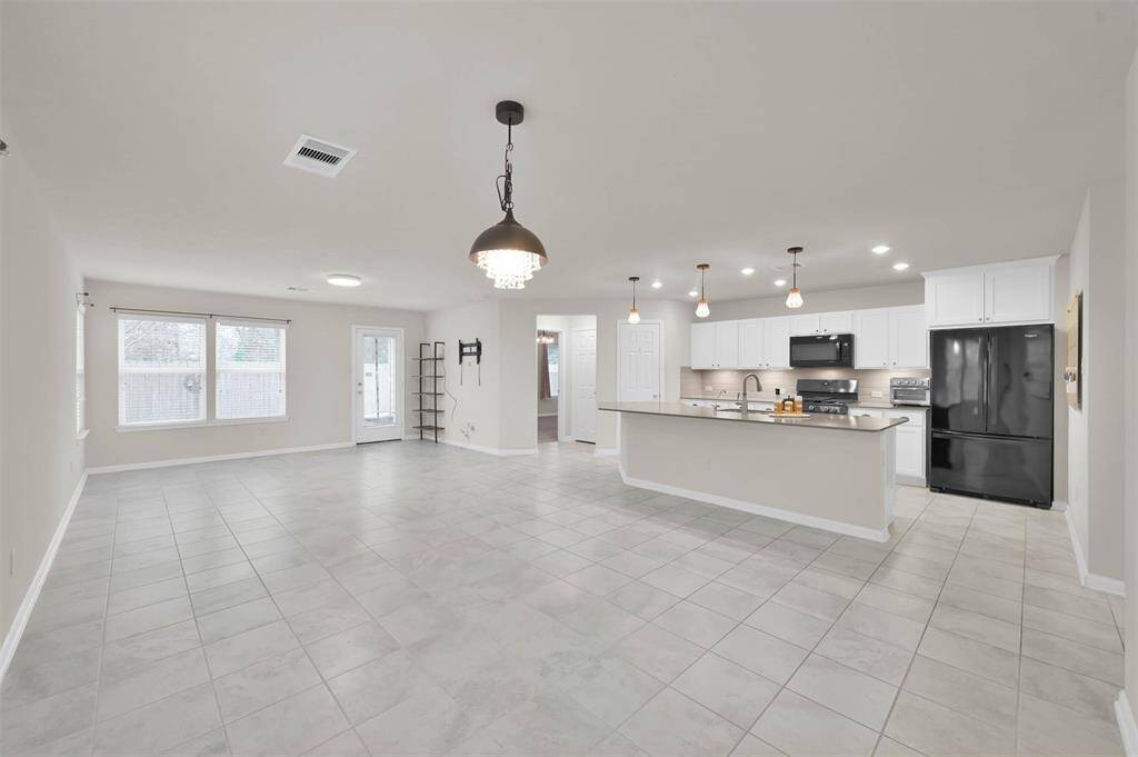 At end of entry hallway, an open area combining living/kitchen/ dining room