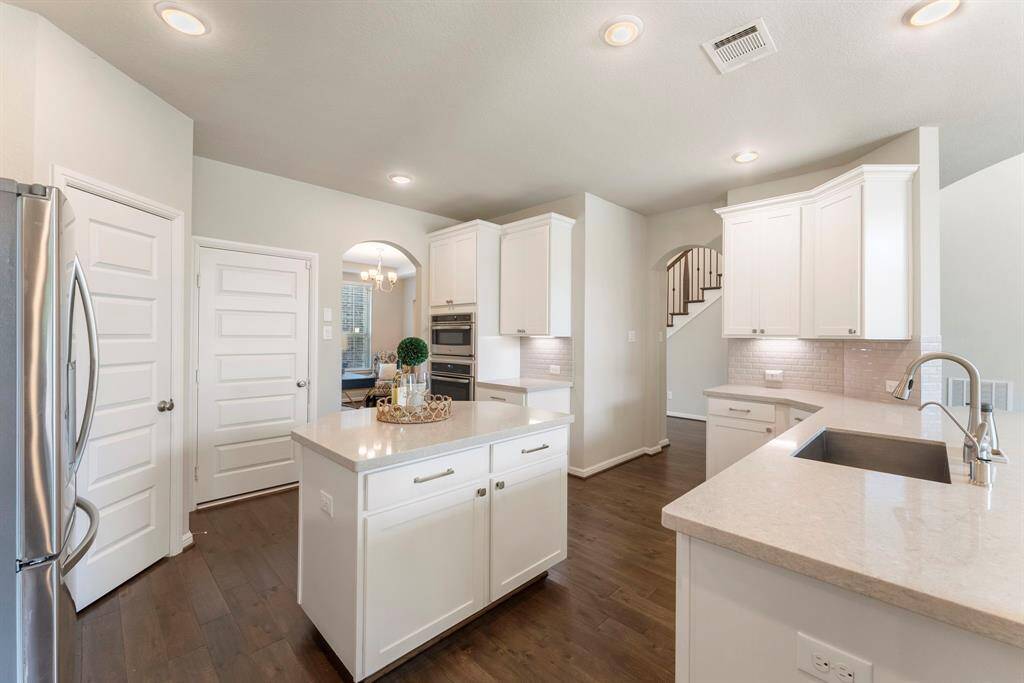 Open arches to formal dining room and entry foyer.