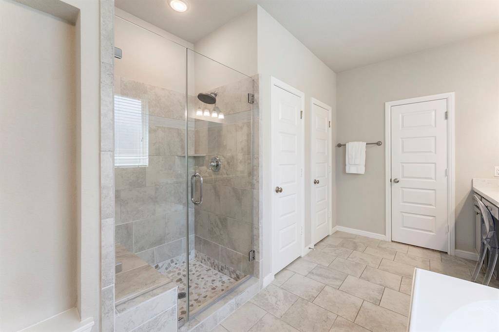 At entry to primary bath is an art niche on left, followed by the oversized walk in shower.