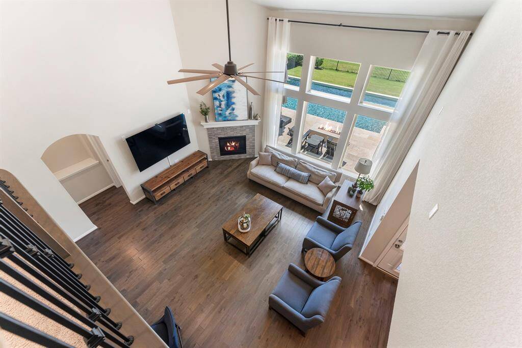 The two story windows offer amazing light and views to the beautiful outdoors. Photo shows the primary bedroom entry at left with the privacy buffer after arch before door.