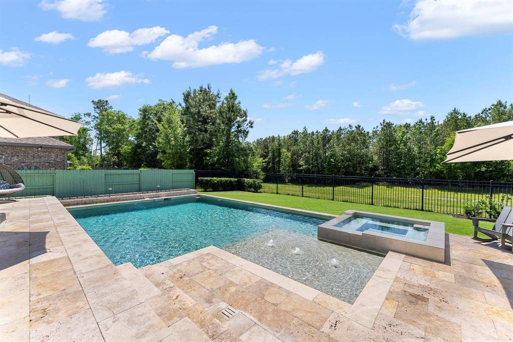 Heated Pool and Spa features a modern angular shape, a Pebble Tec finish, color changing light package, and a tanning ledge with bubblers.  Entertainers dream with the large size of the stone (travertine) decking. The stairs and level change add a beautiful designer touch.