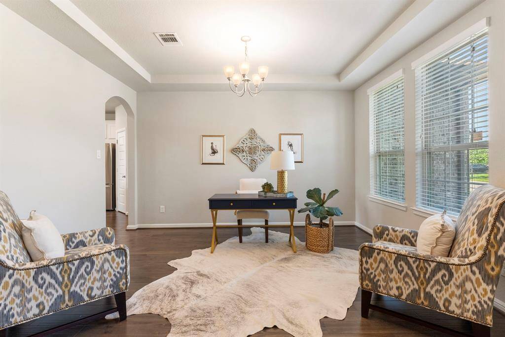 Formal dining with tray ceiling at front of home is currently being used as second office and conversation area.