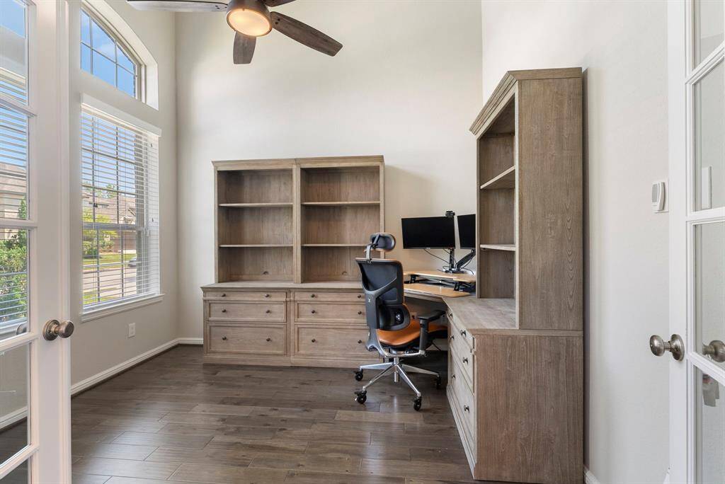 Bright home office just inside front door with large windows and ultra high ceiling.