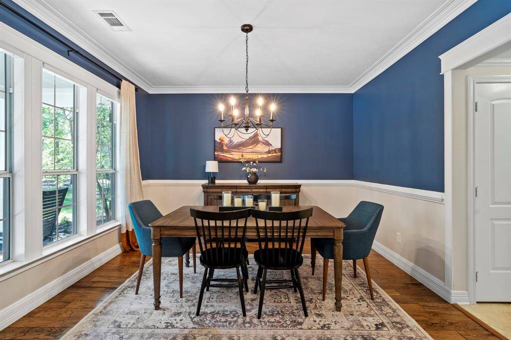 Notice the crown molding, chair rail detailing, and a wall of windows.