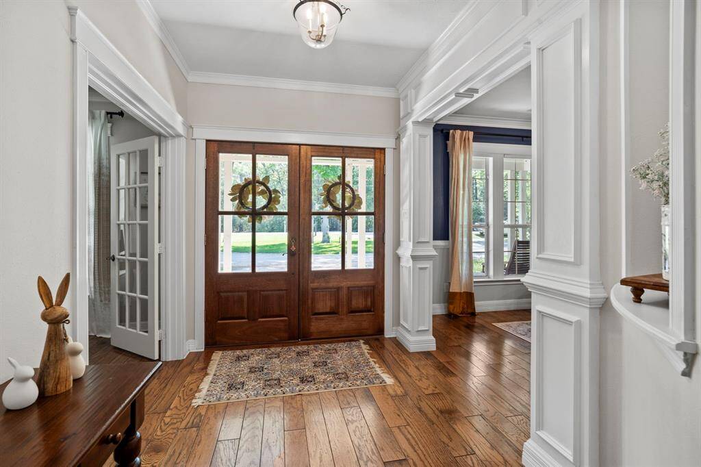 Just off the entry, you'll find access to the private home office through French doors and the formal dining room framed by stately columns and large front-facing windows.