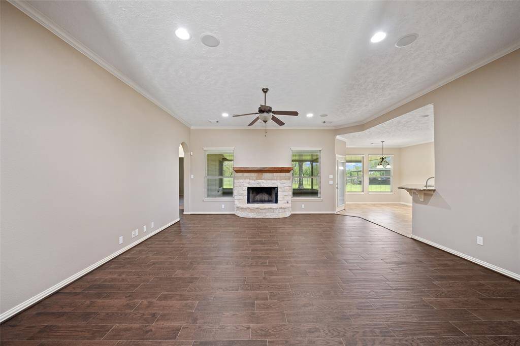 Gather ‘round the stone fireplace and soak in serene backyard views — this inviting living space is made for connection and comfort.
