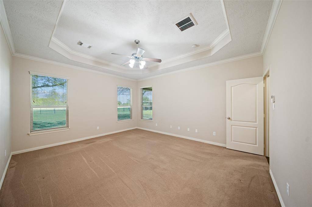 Tray ceilings, backyard views, and plenty of natural light — this primary bedroom is equal parts spacious and serene.