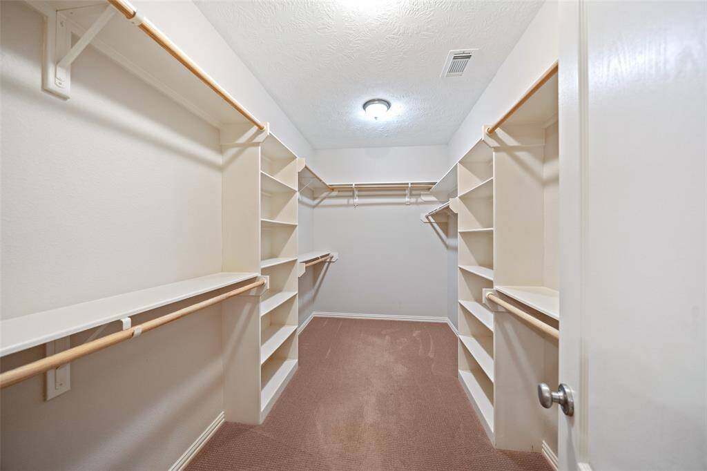 Ample built-ins and hanging space make this walk-in closet a practical standout in the primary suite.