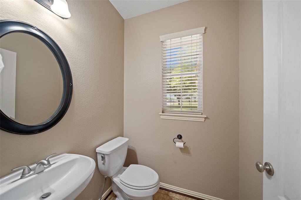 A charming half bath conveniently located for guests — and that window brings in lovely natural light!