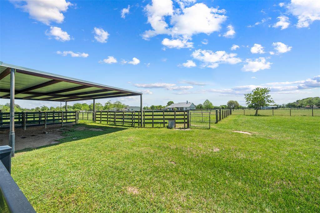 A generously sized covered space with secure fencing, ideal for shade and shelter — ready to accommodate your horses, cattle, or 4H projects with ease.