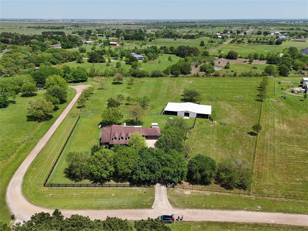 A picture-perfect view of the entire property—rolling pastures, mature trees, and your dream setup all in one frame.