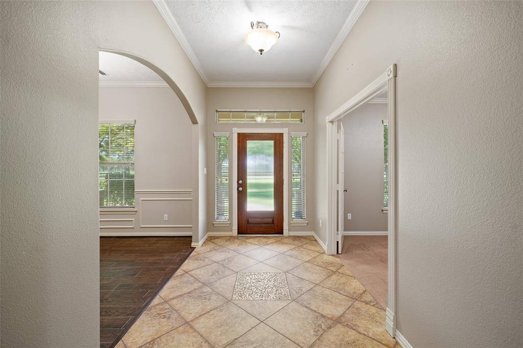 Step inside to a warm, light-filled entryway with stylish tile detail and beautiful views straight to the front yard.
