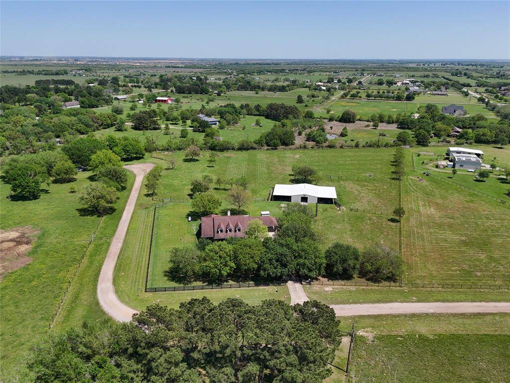 Sprawling acreage, a welcoming tree-lined drive, and a well-positioned barn—this aerial gives you the full lay of the land.
