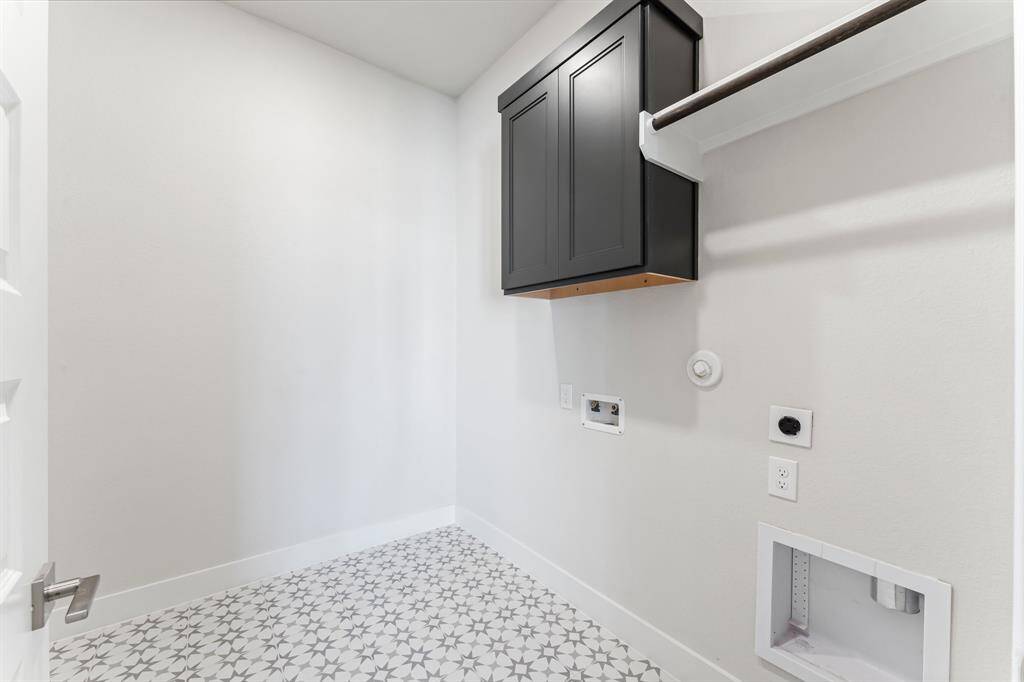 Utility Room with Washer and Dryer Connections, Drying Bar, and Storage Cabinet.