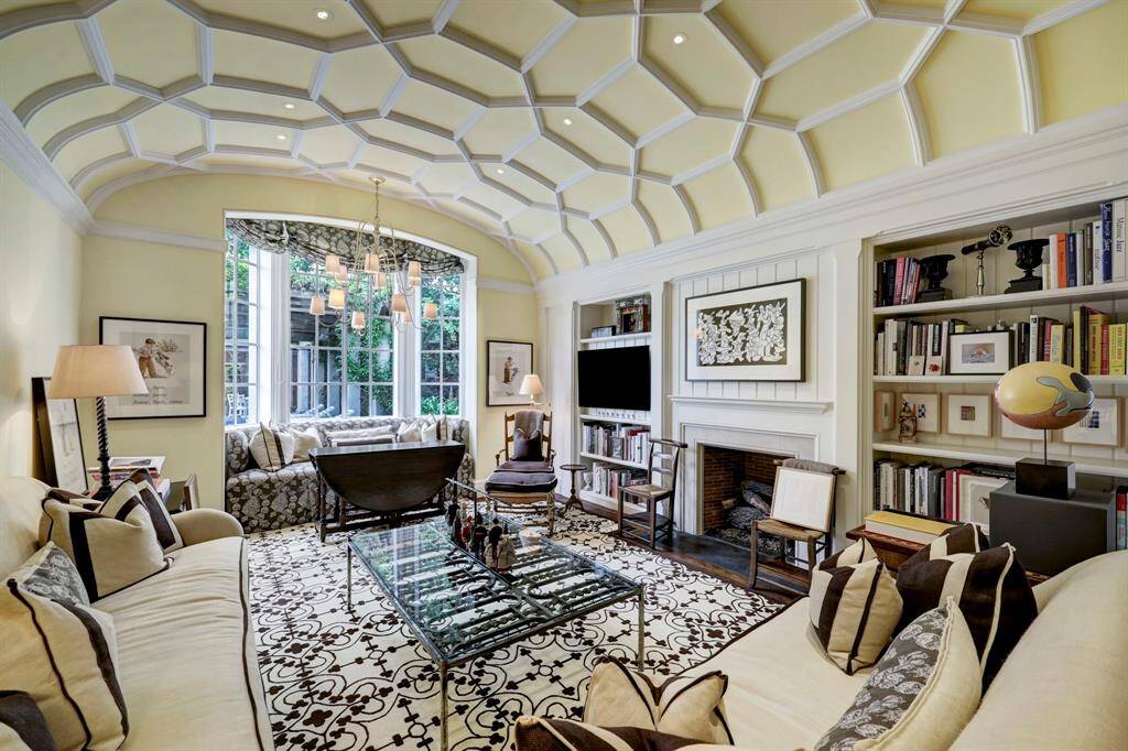 The Breakfast Room with barrel ceiling and custom millwork and fireplace. The breakfast room table is located opposite pictured sitting area.