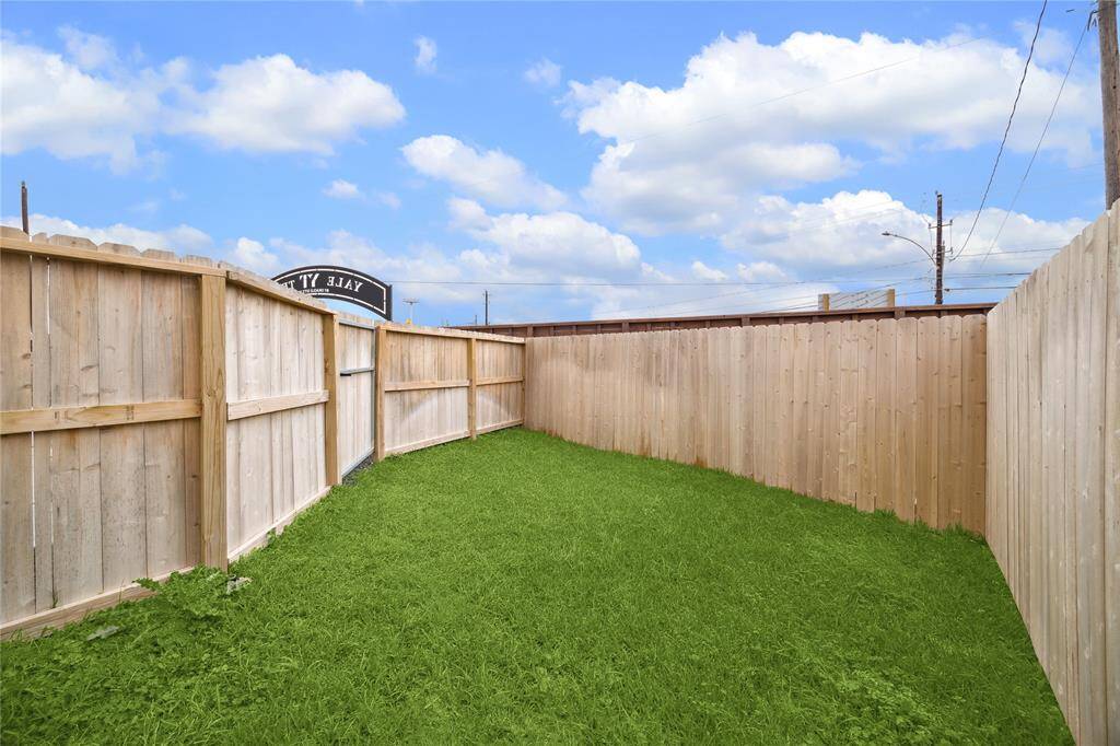 Serene and private backyard, perfect for relaxation or play, with a sturdy wooden fence and lush green grass.