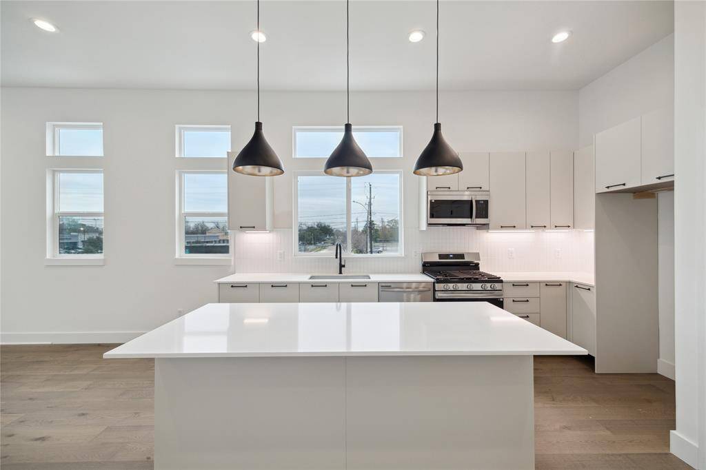 Spacious kitchen with modern fixtures, sleek cabinetry, and abundant natural light. Perfect for culinary enthusiasts.