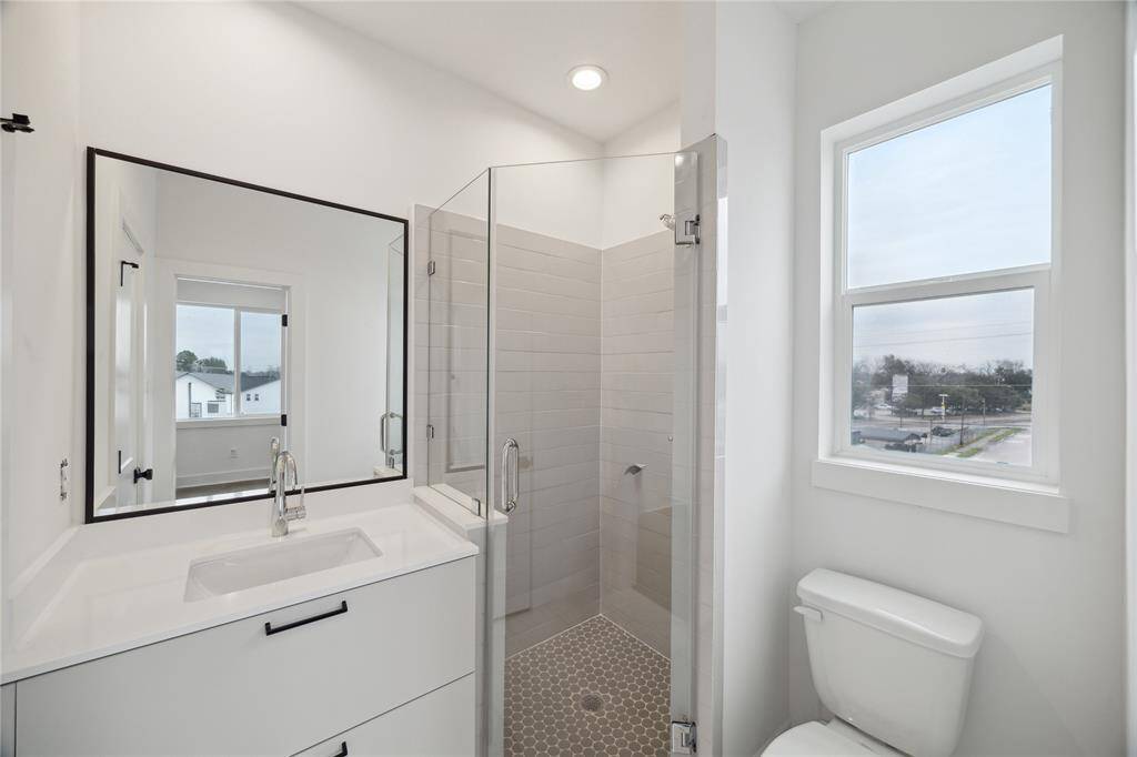 Bright and inviting third-floor bedroom featuring a modern en-suite bathroom and expansive windows with serene views.