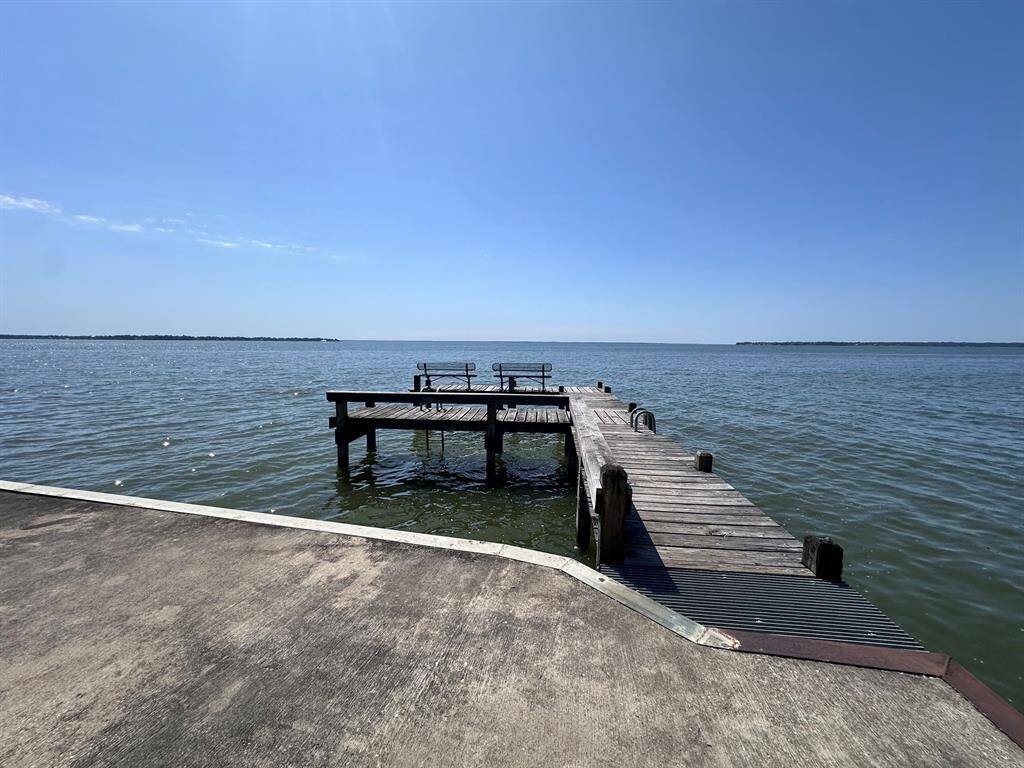 This photo showcases a serene waterfront view with a wooden dock extending into calm waters, perfect for enjoying peaceful sunsets and water activities.