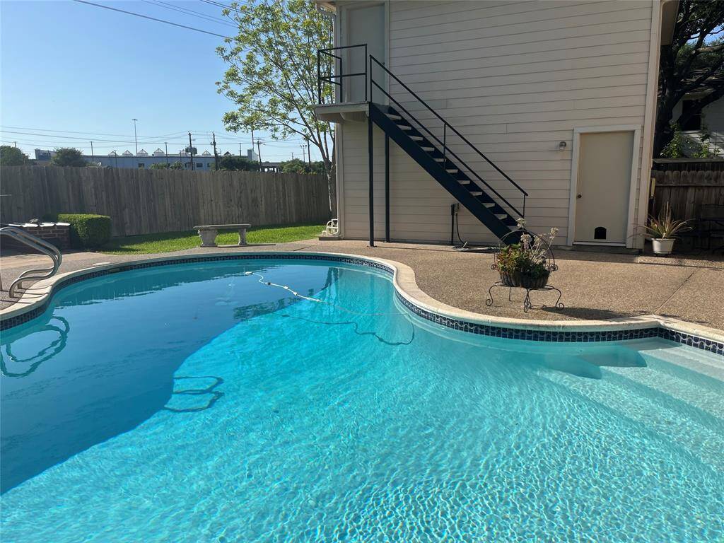 The large lot includes a grassy area beyond the pool—perfect for pets and playtime with the kids.