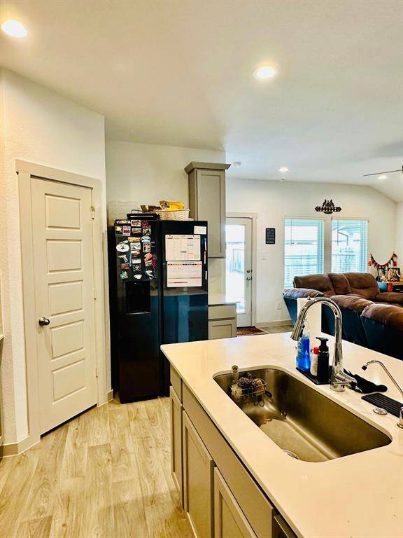 Modern kitchen with sleek light wood cabinets, a spacious island with a sink, and stainless steel appliances. The room features ample counter space, recessed lighting, and a stylish backsplash, creating a bright and inviting space for cooking and entertaining.