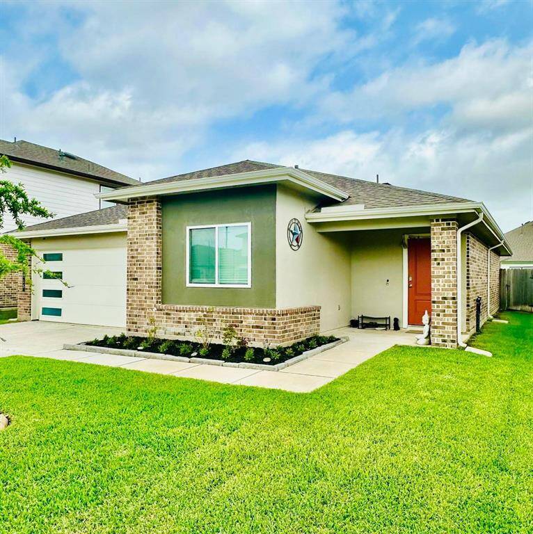 Charming single-story home with a modern exterior, featuring a well-maintained lawn in front. The property includes a two-car garage and a covered porch, perfect for a cozy and inviting entrance.