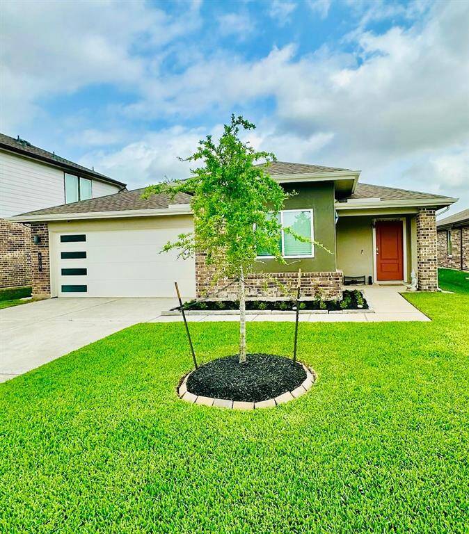 Charming single-story home with a modern exterior, featuring a well-maintained lawn in front. The property includes a two-car garage and a covered porch, perfect for a cozy and inviting entrance.