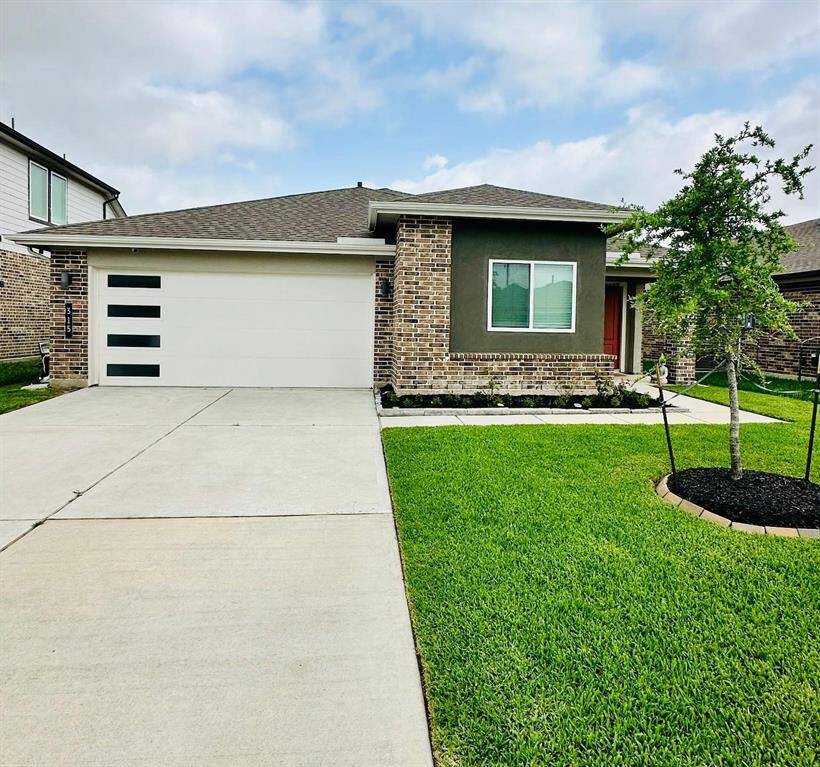 Charming single-story home with a modern exterior, featuring a well-maintained lawn in front. The property includes a two-car garage and a covered porch, perfect for a cozy and inviting entrance.