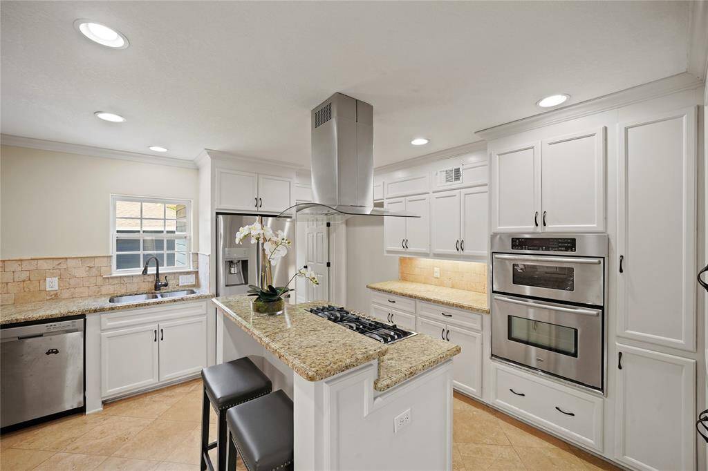 Enjoy a lovely view of the backyard from the window above the kitchen sink, complemented by lavish under-cabinet lighting that elevates both style and ambiance.