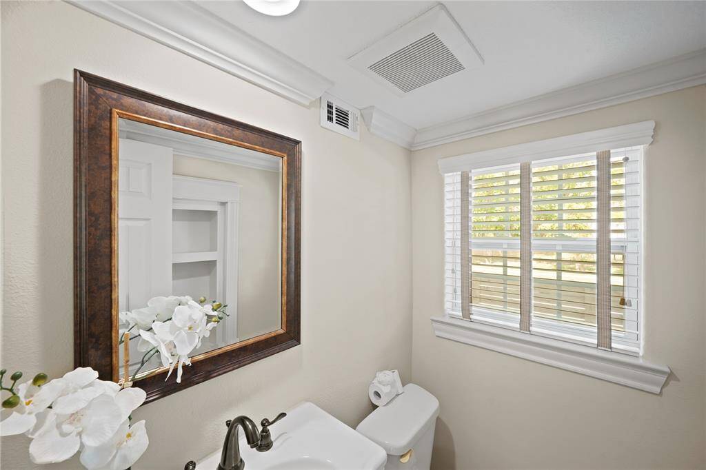A convenient half bath just off the foyer, with access to additional storage cleverly tucked beneath the stairs.