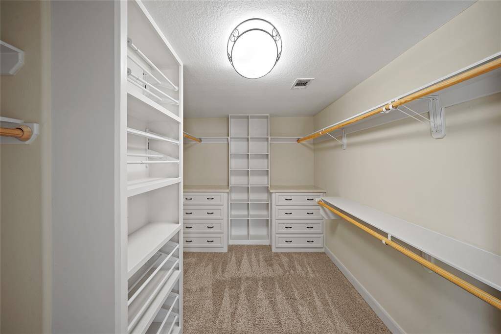The luxurious custom closet offers ample space with sophisticated built-in storage, making it both stylish and functional.