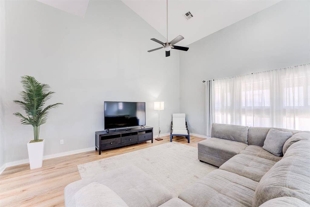 Large living room on the 2nd floor, perfect for entertaining and full of natural light! Look at those large windows and vaulted ceilings!
